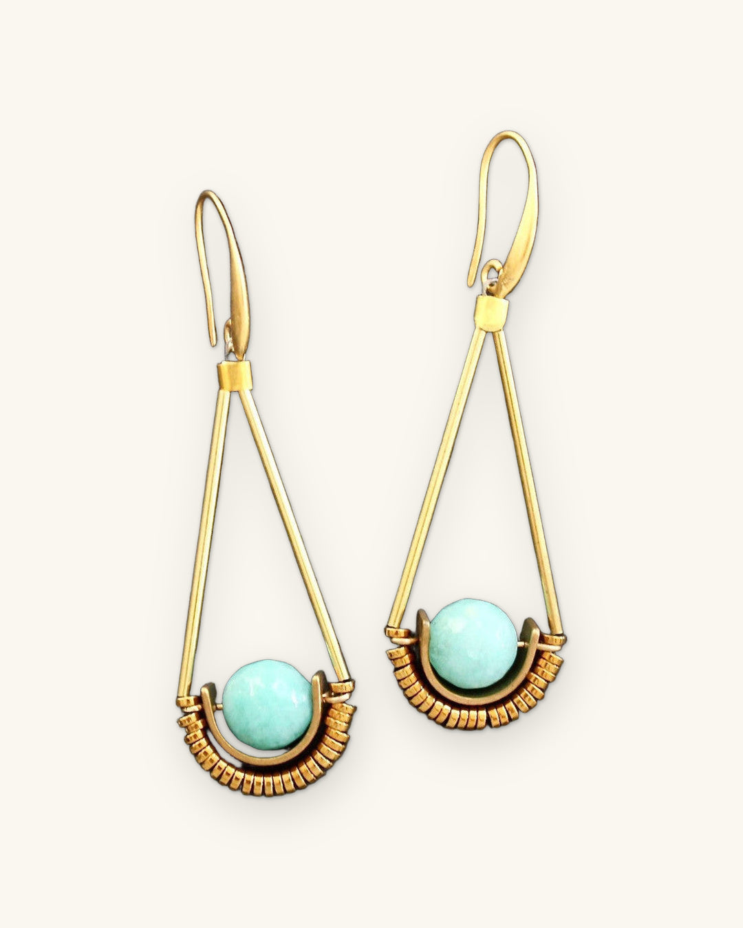 Amazonite sphere drop earrings in long gold triangle frames, hand-wrapped wire made in the USA, on black slate, shown on a sand background