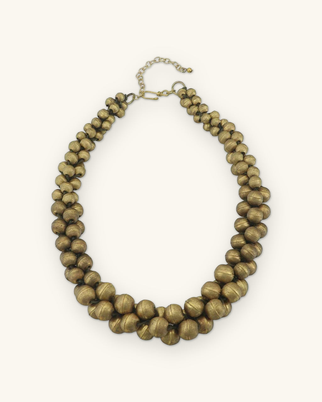 Full view of the antique gold-tone twisted multi-strand bead necklace with clasp and extender, shown on a sand background