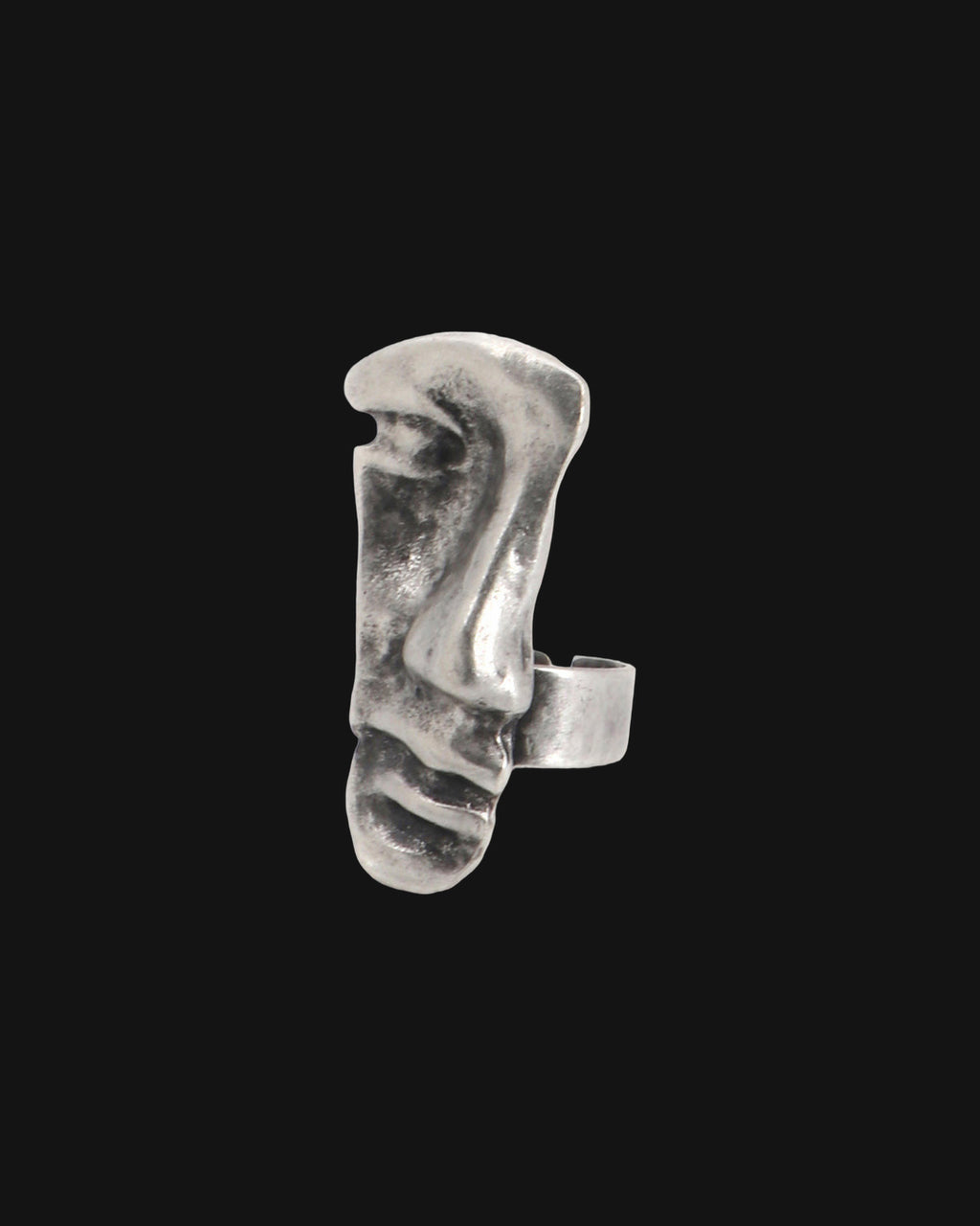 Close-up of the antique silver-tone face ring with textured brow, nose and ridged lips, shown on a black background