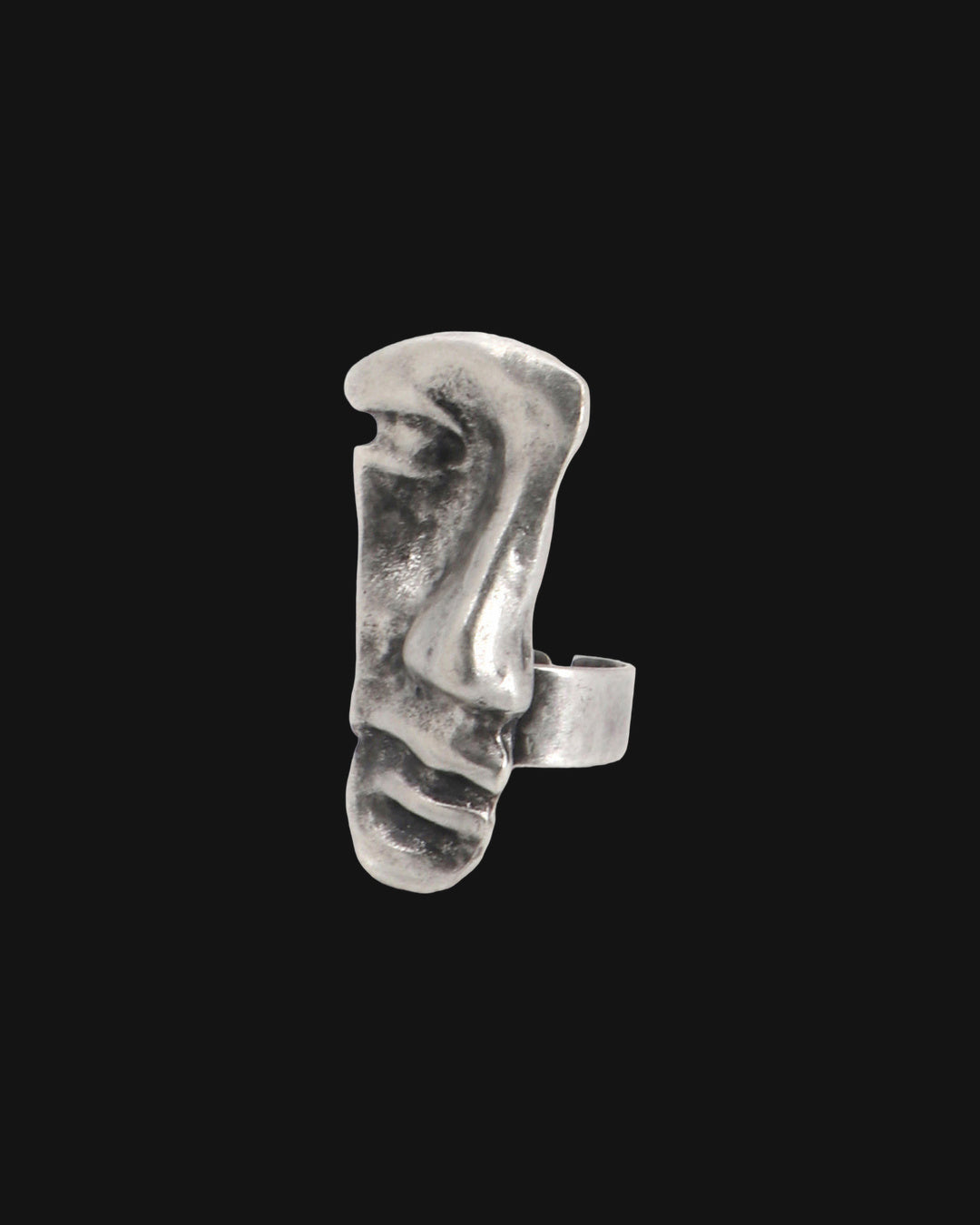 Close-up of the antique silver-tone face ring with textured brow, nose and ridged lips, shown on a black background