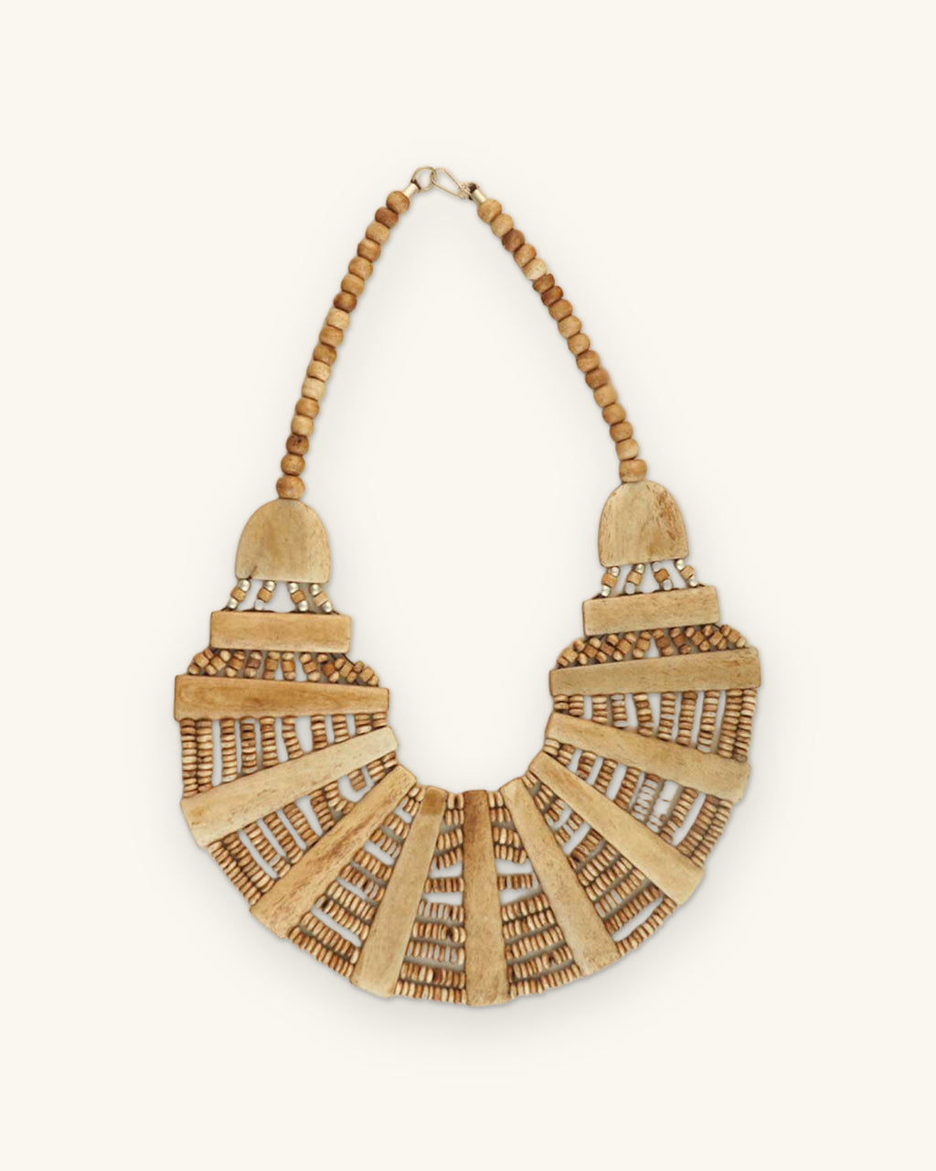 Fan-shaped bone bib necklace laid flat, bone bars radiating between rows of small wood beads, shown on a sand background