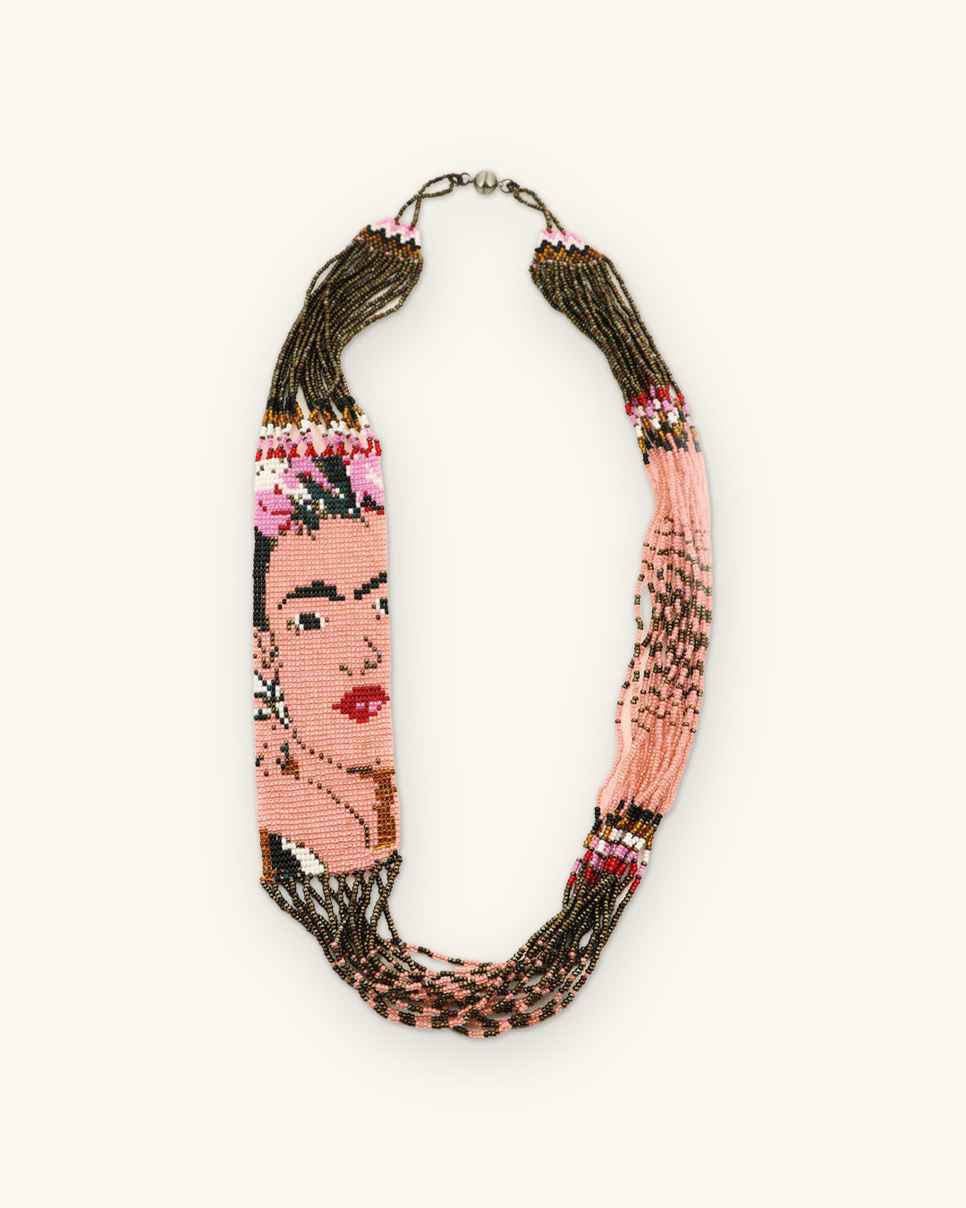 Full view of the beaded Frida portrait necklace with bronze bead strands and clasp, shown on a sand background
