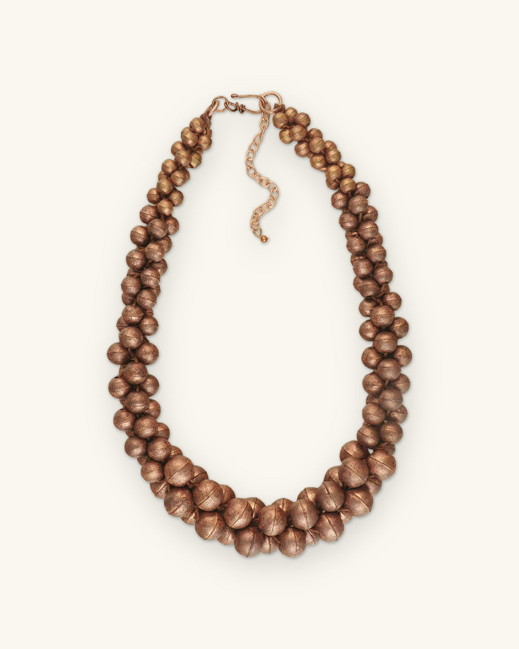 Ribbed copper bead cluster necklace on twisted multi-strand cord with chain extender, made in India, shown on a sand background
