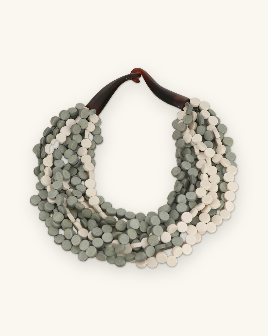Nine-strand gray and cream wood disc necklace with a brown horn clasp, Filipino wood bead layering, shown on a sand background