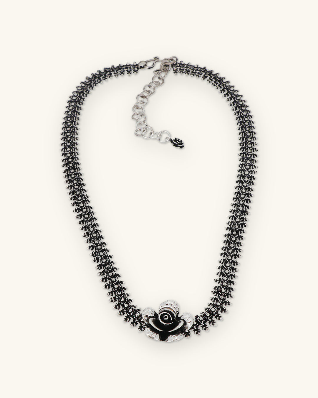 Hill tribe silver floret collar necklace with oxidized rose centerpiece, repoussé and chasing from Laos, shown on a sand background