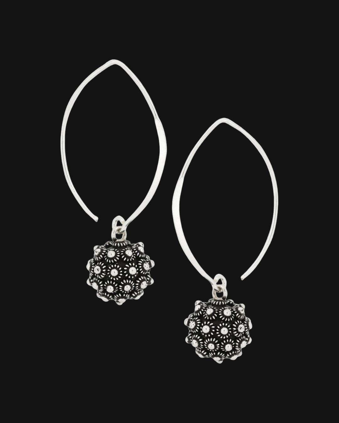 Pair of oxidized silver floret ball earrings on open marquise-shaped sterling silver threaders, shown on a black background
