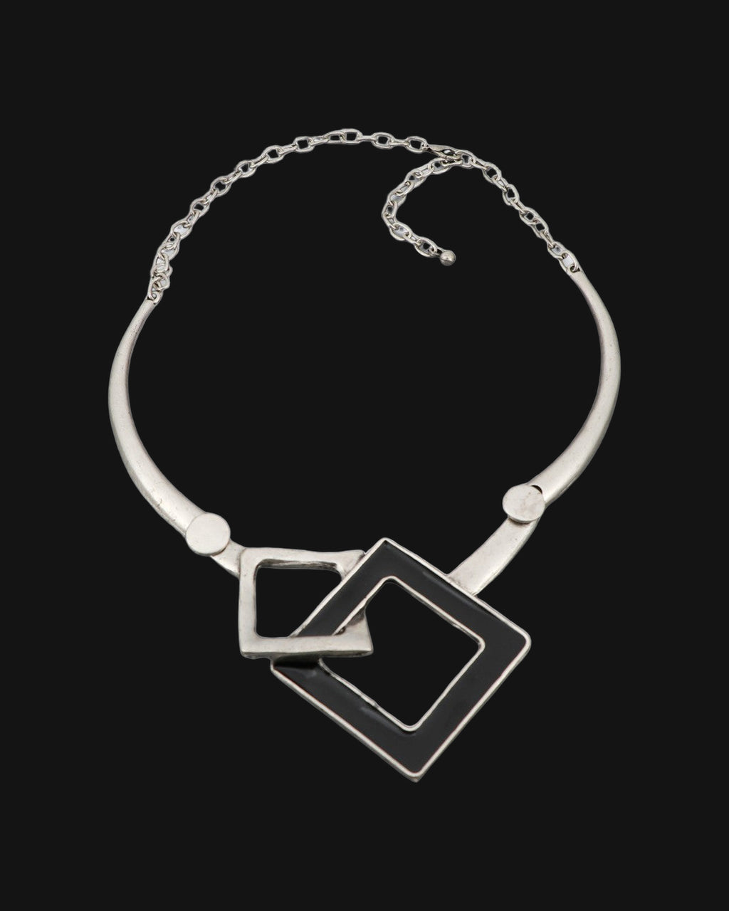 Interlocking squares collar necklace laid flat showing the rigid silver-tone collar and chain closure, shown on a black background