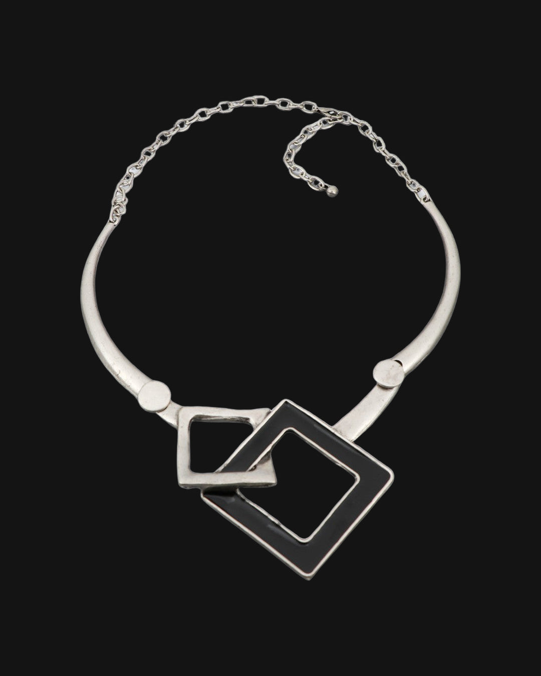 Interlocking squares collar necklace laid flat showing the rigid silver-tone collar and chain closure, shown on a black background