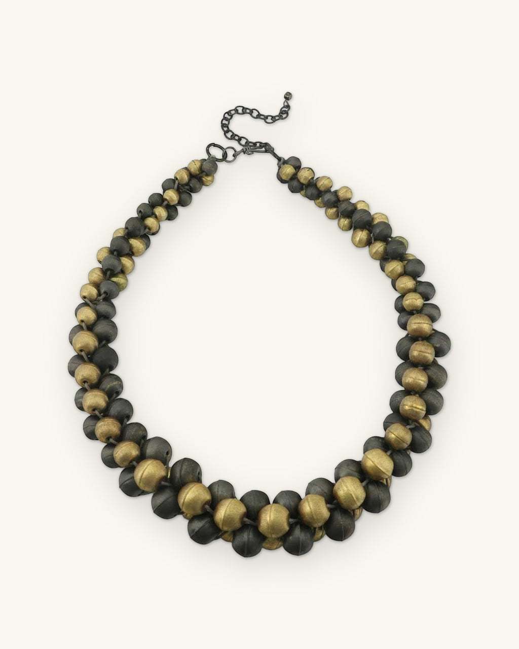 Full round of the antique gold and gunmetal bead collar with graduated beads at the front, shown on a sand background