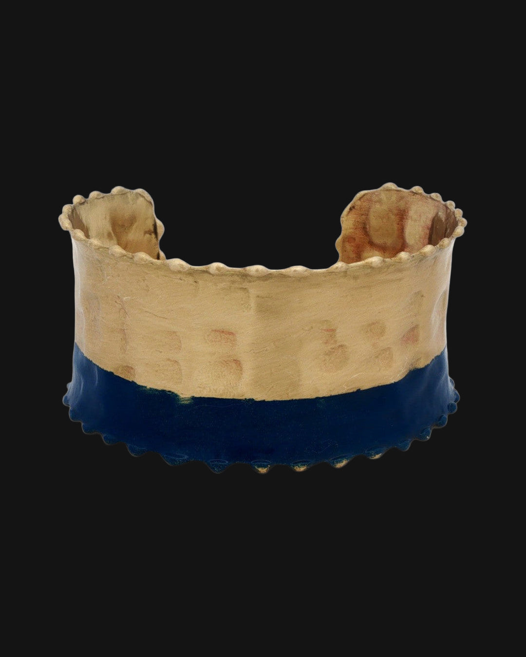 Front of the two-tone hammered cuff with antique gold top and indigo lower band, shown on a black background