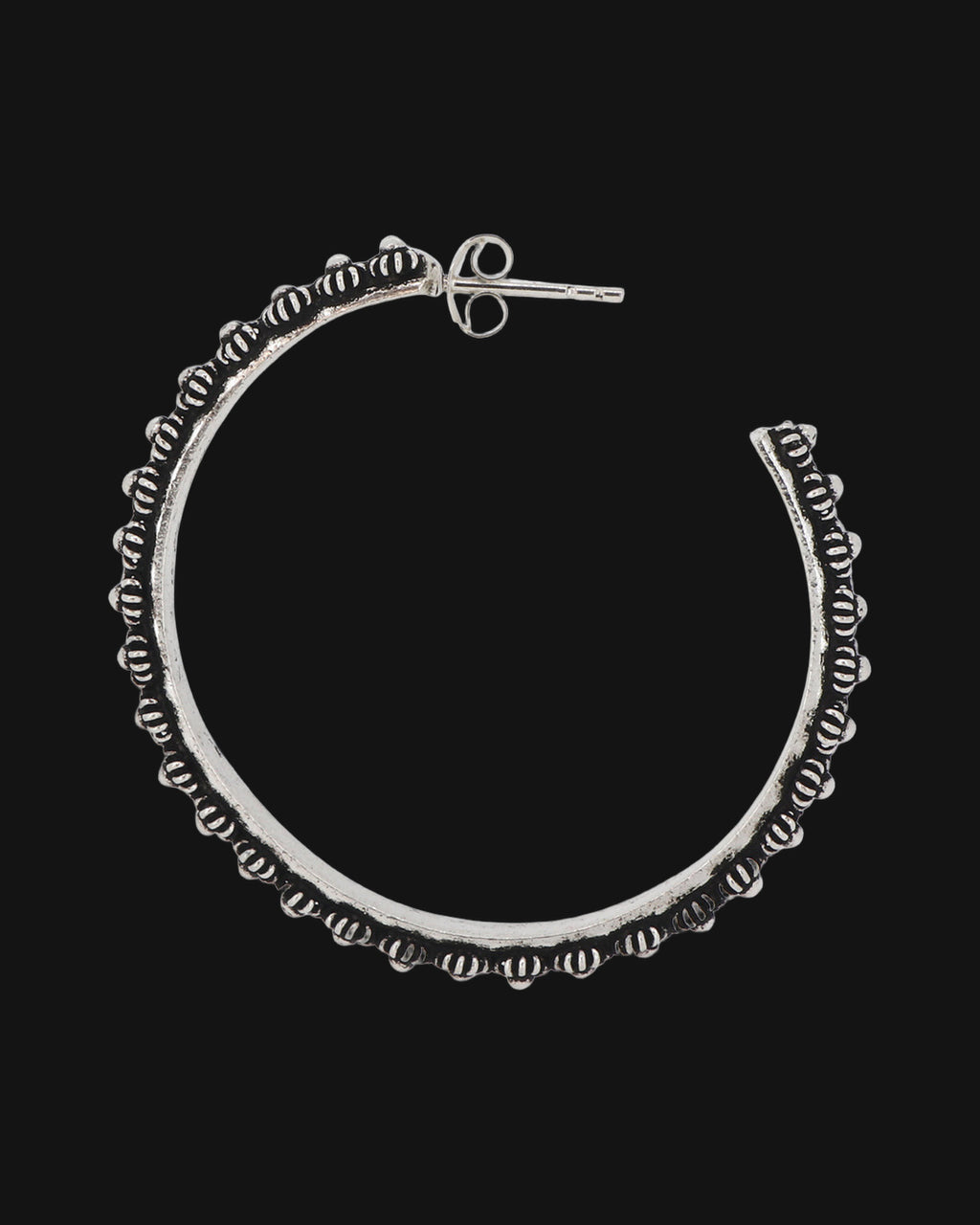 Pair of oxidized hill tribe silver floral hoop earrings set side by side, showing the post backs, shown on a black background