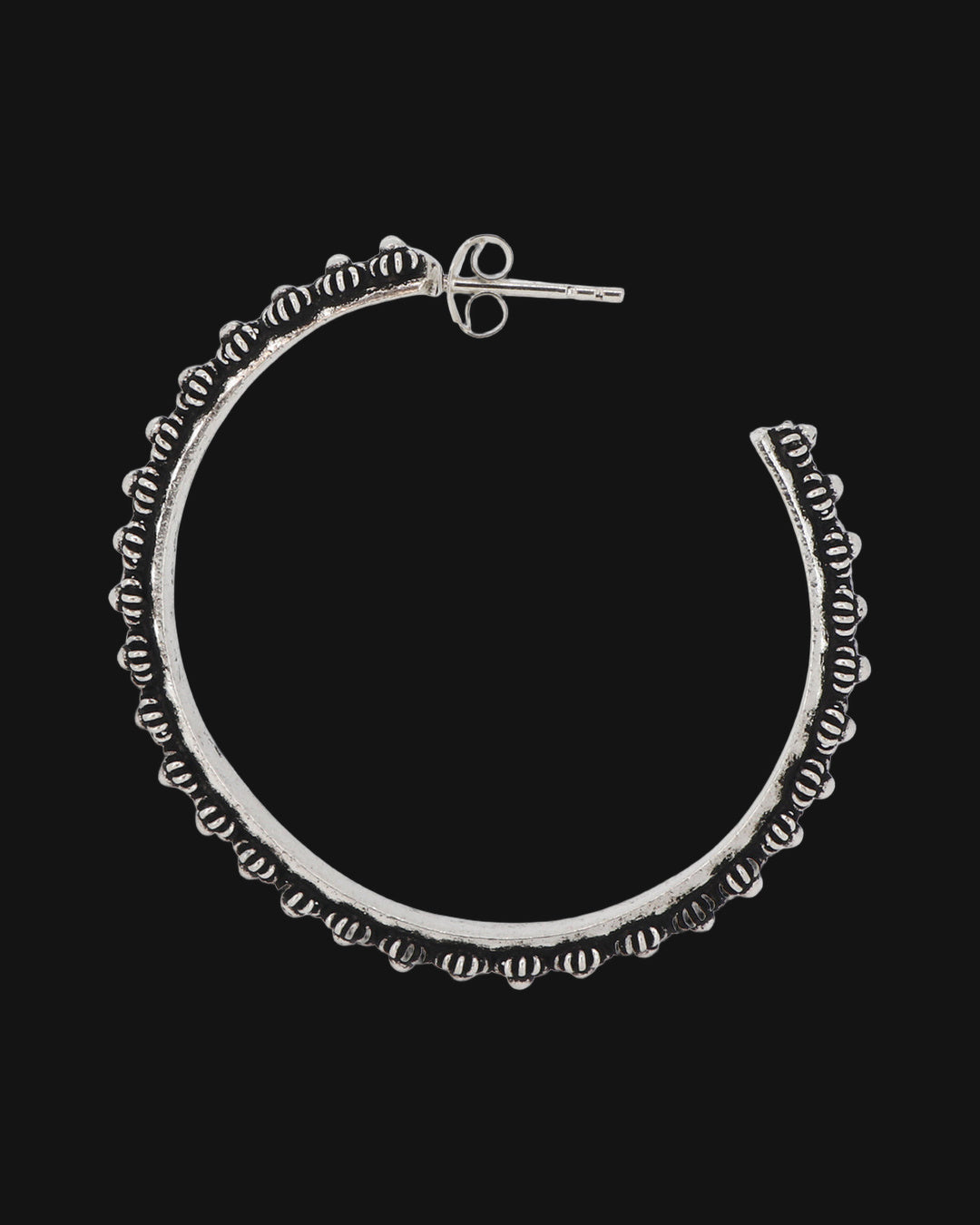 Pair of oxidized hill tribe silver floral hoop earrings set side by side, showing the post backs, shown on a black background