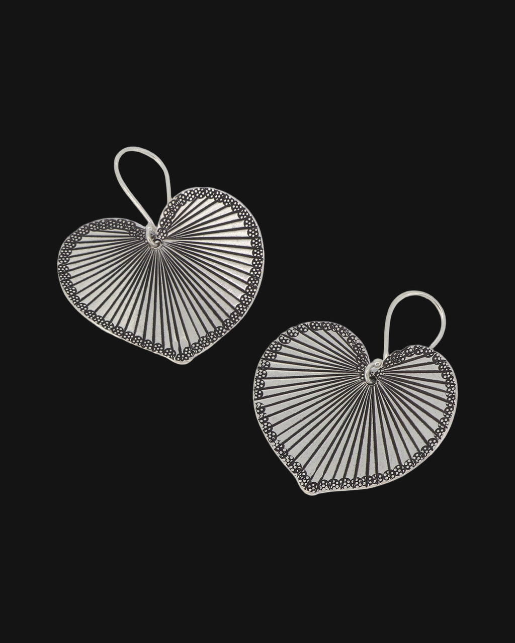 Pair of silver heart-leaf drop earrings with radiating engraved veins and beaded rims, shown on a black background