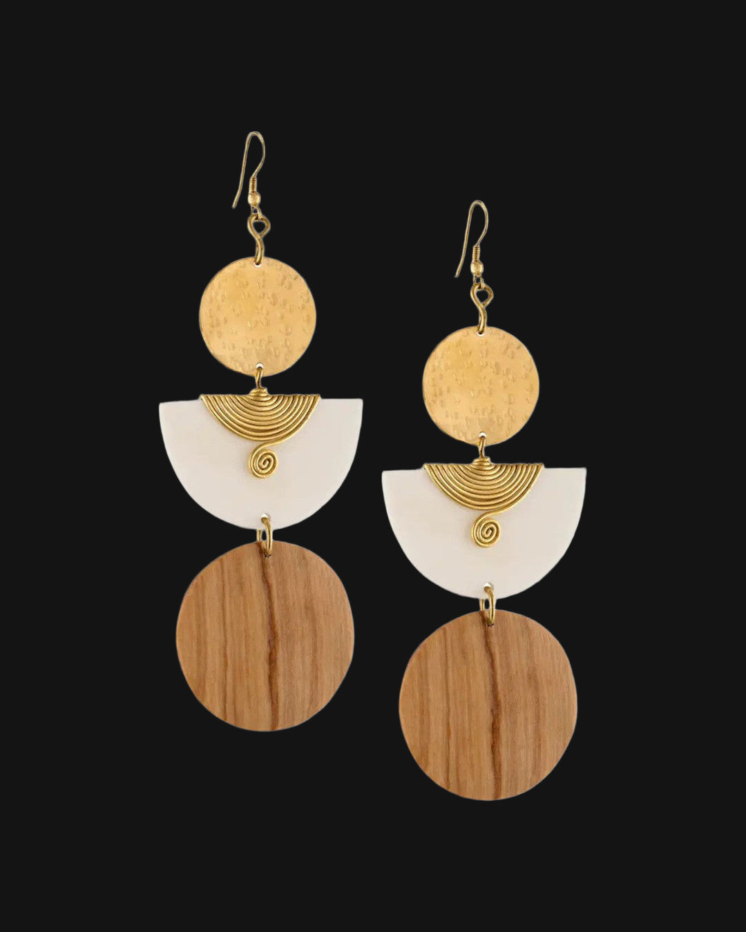 Pair of tiered brass disc, bone half-moon and wood circle earrings with coiled brass wire spirals, shown on a black background