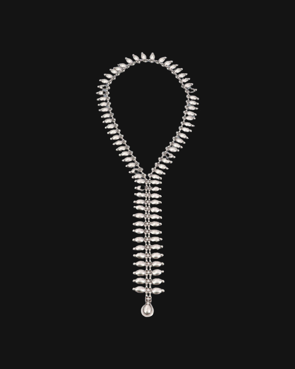 Full length of the antiqued silver-tone fringe lariat necklace laid flat, ending in a teardrop, shown on a black background