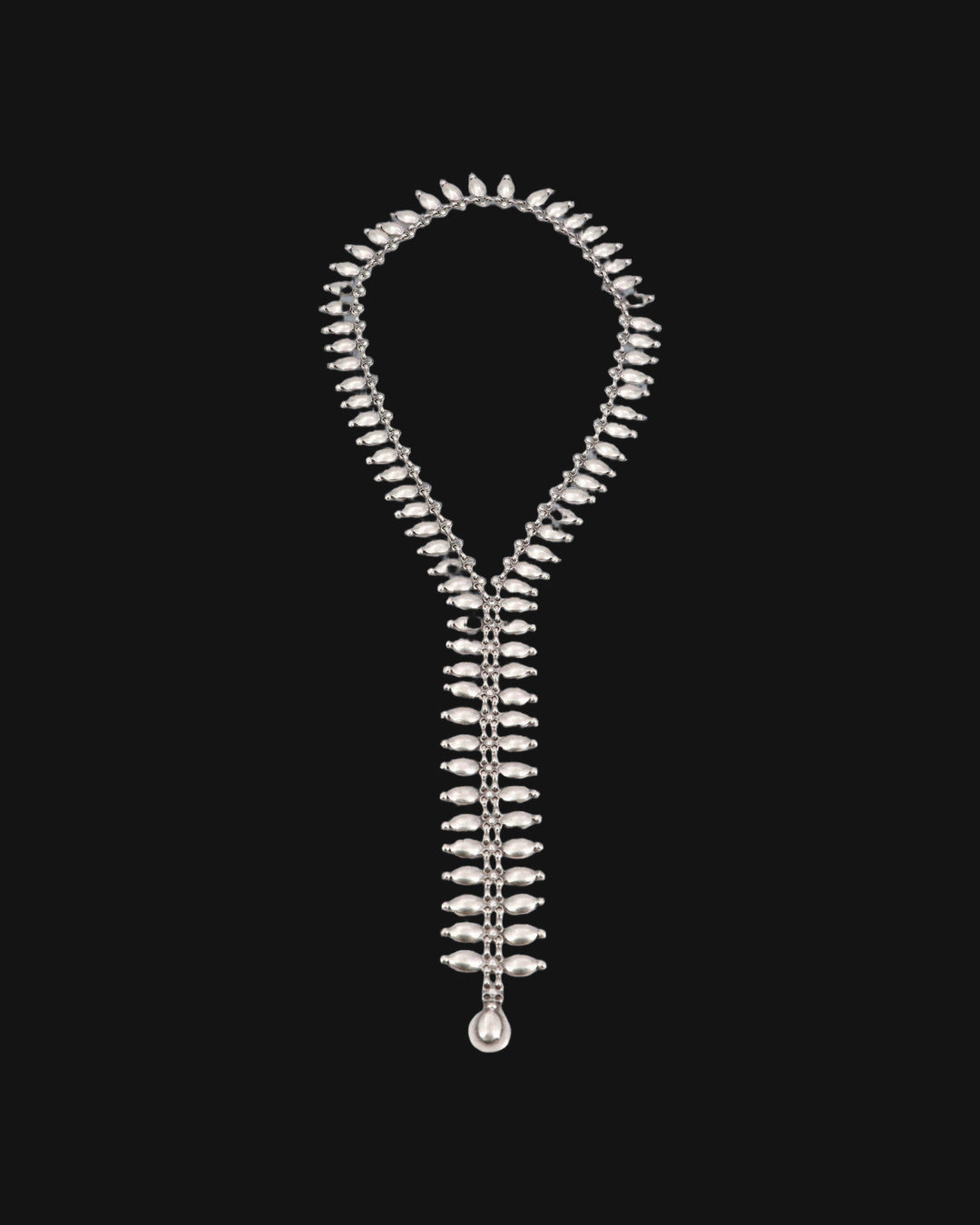 Full length of the antiqued silver-tone fringe lariat necklace laid flat, ending in a teardrop, shown on a black background