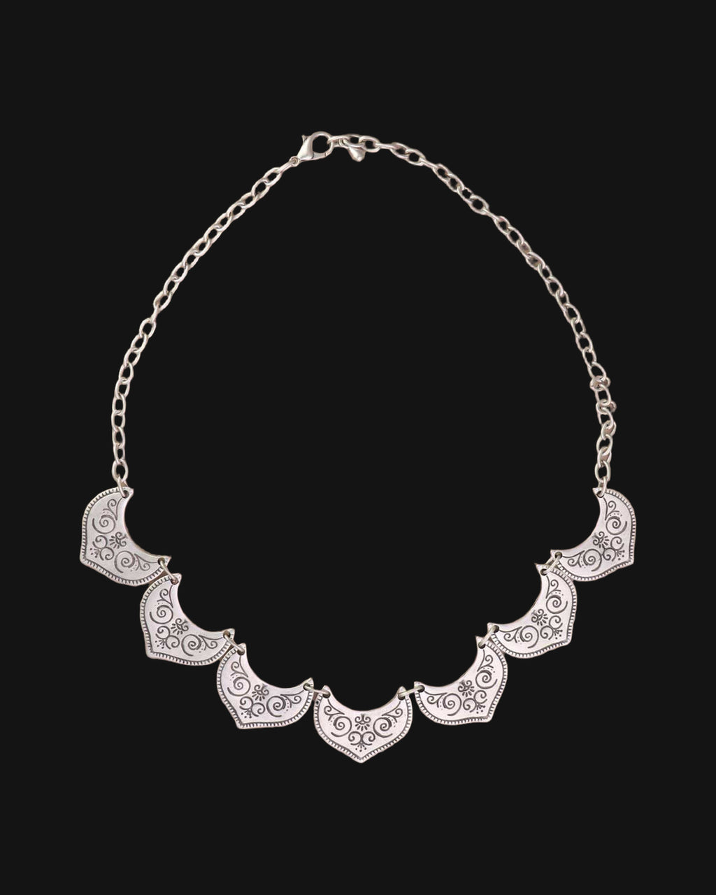 Silver-tone fan-plate bib necklace laid flat with its link chain and lobster clasp, shown on a black background