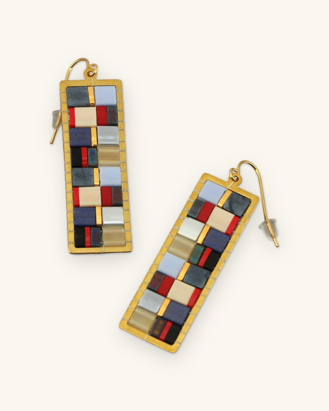 Mosaic Tila bead drop earrings in Blue with navy, cream and red tiles in gold-tone brass frames, shown on a sand background
