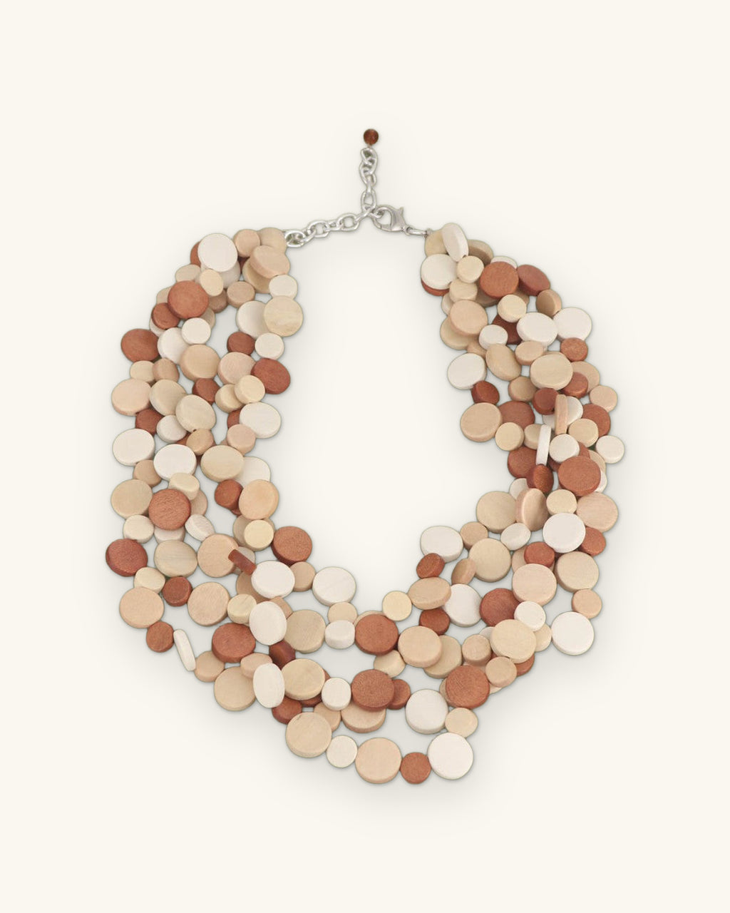 Layered wood disc necklace in terracotta, tan and cream with silver-tone chain closure, made in the Philippines, shown on a sand background