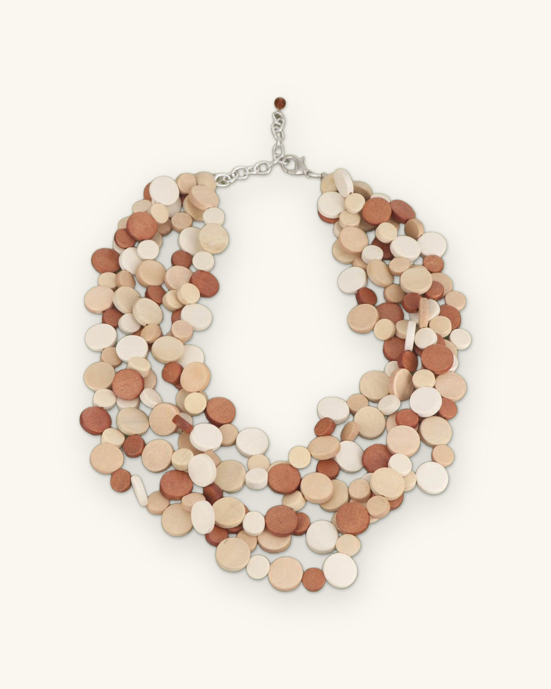 Layered wood disc necklace in terracotta, tan and cream with silver-tone chain closure, made in the Philippines, shown on a sand background