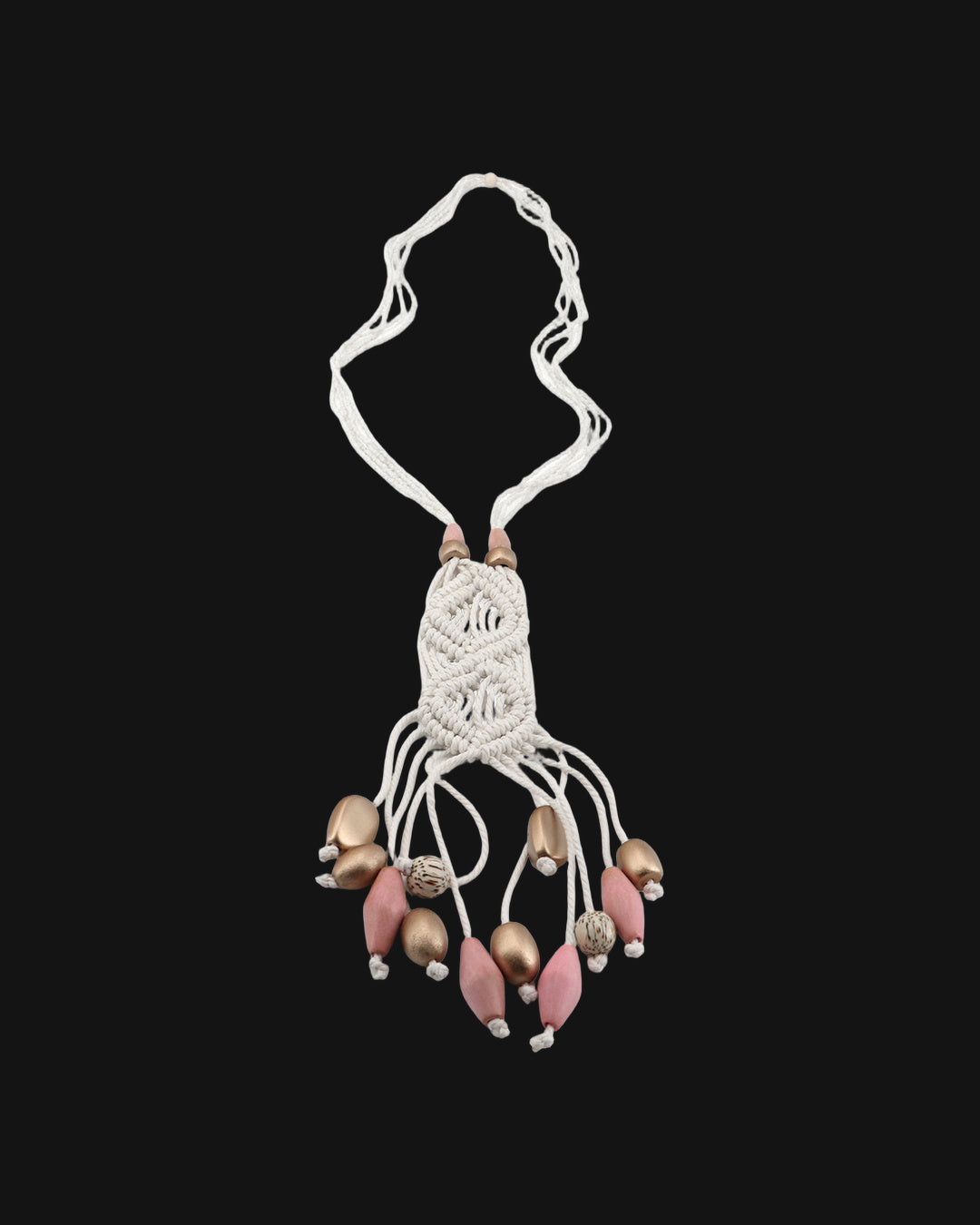 Full view of the ivory macramé pendant on seed bead strands with a fringe of pink and metallic wood beads, shown on a black background