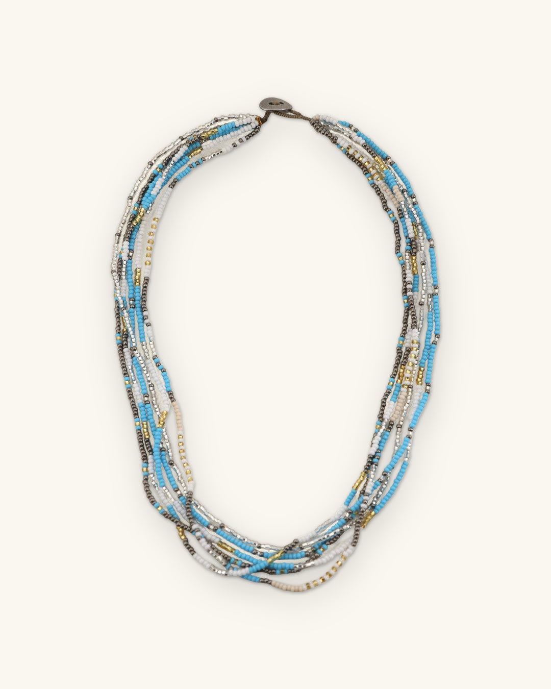 Twisted turquoise, white, silver and gold seed bead strands with a button closure, laid flat, shown on a sand background