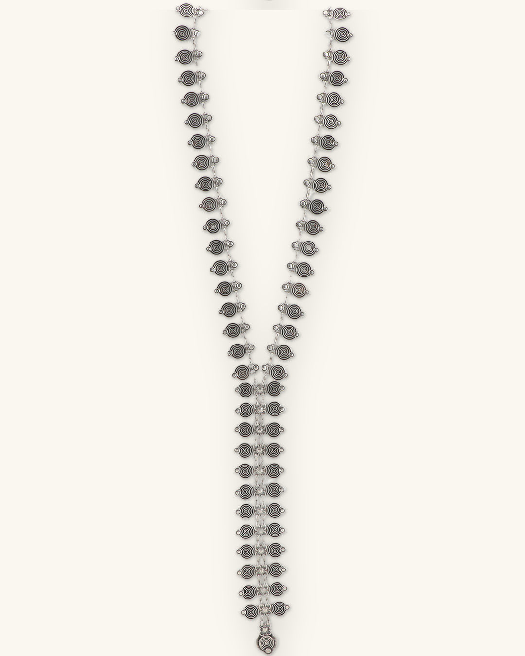 Spiral-stamped silver Y-drop necklace, straight front view ending in a small teardrop, shown on a sand background