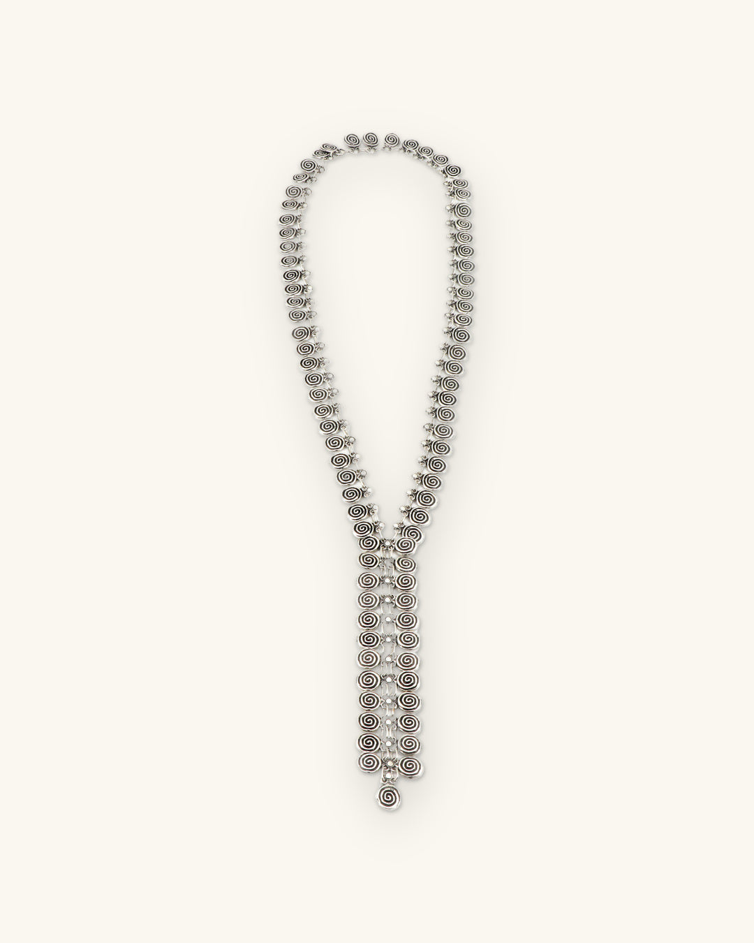 Antique silver-tone spiral-disc Y-drop necklace, full-length view, made in Türkiye, shown on a sand background