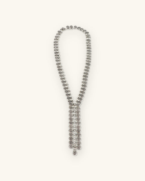 Antique silver-tone spiral-disc Y-drop necklace, full-length view, made in Türkiye, shown on a sand background