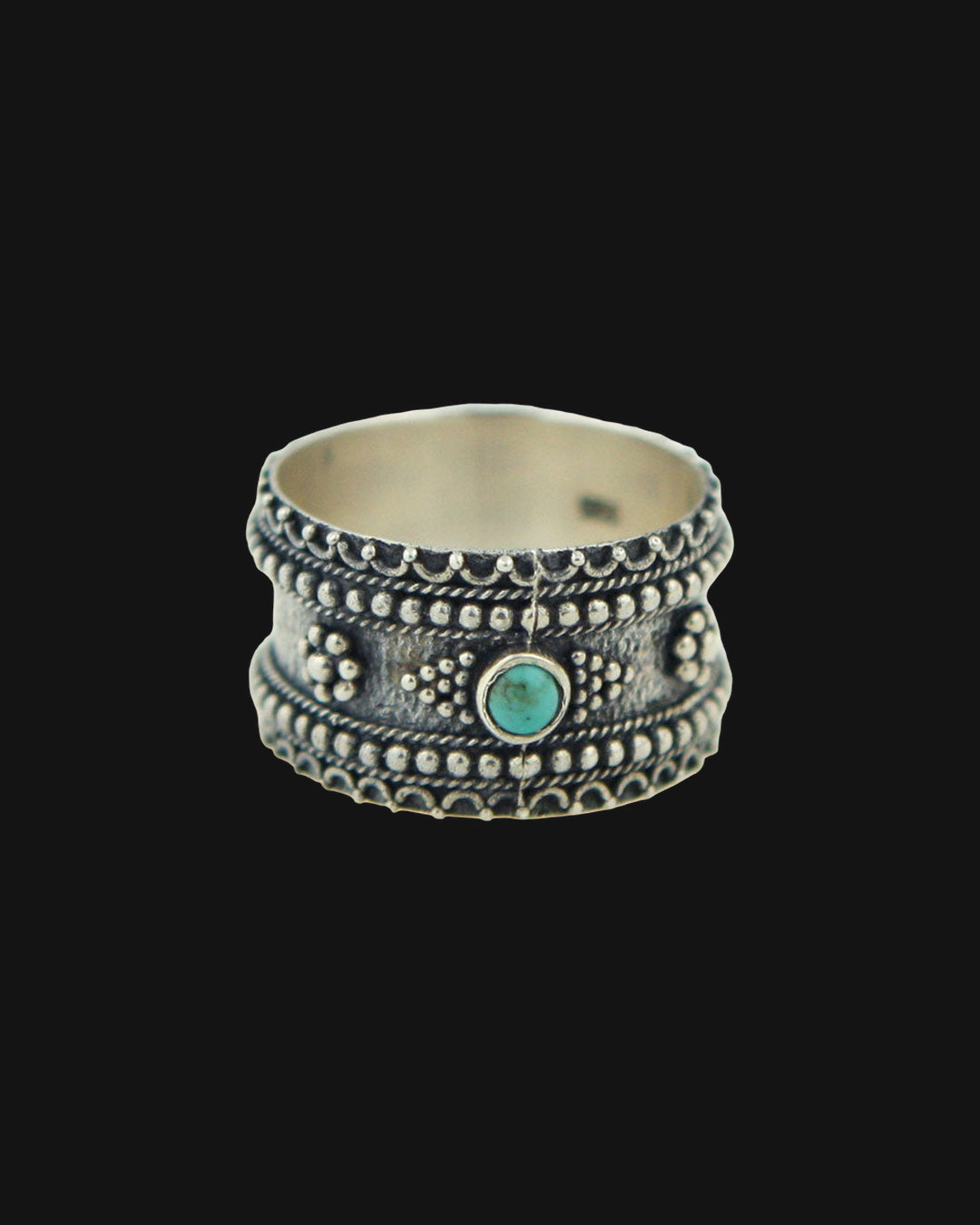 Sterling silver granulation band ring with a bezel-set turquoise center stone, made in Thailand, shown on a black background
