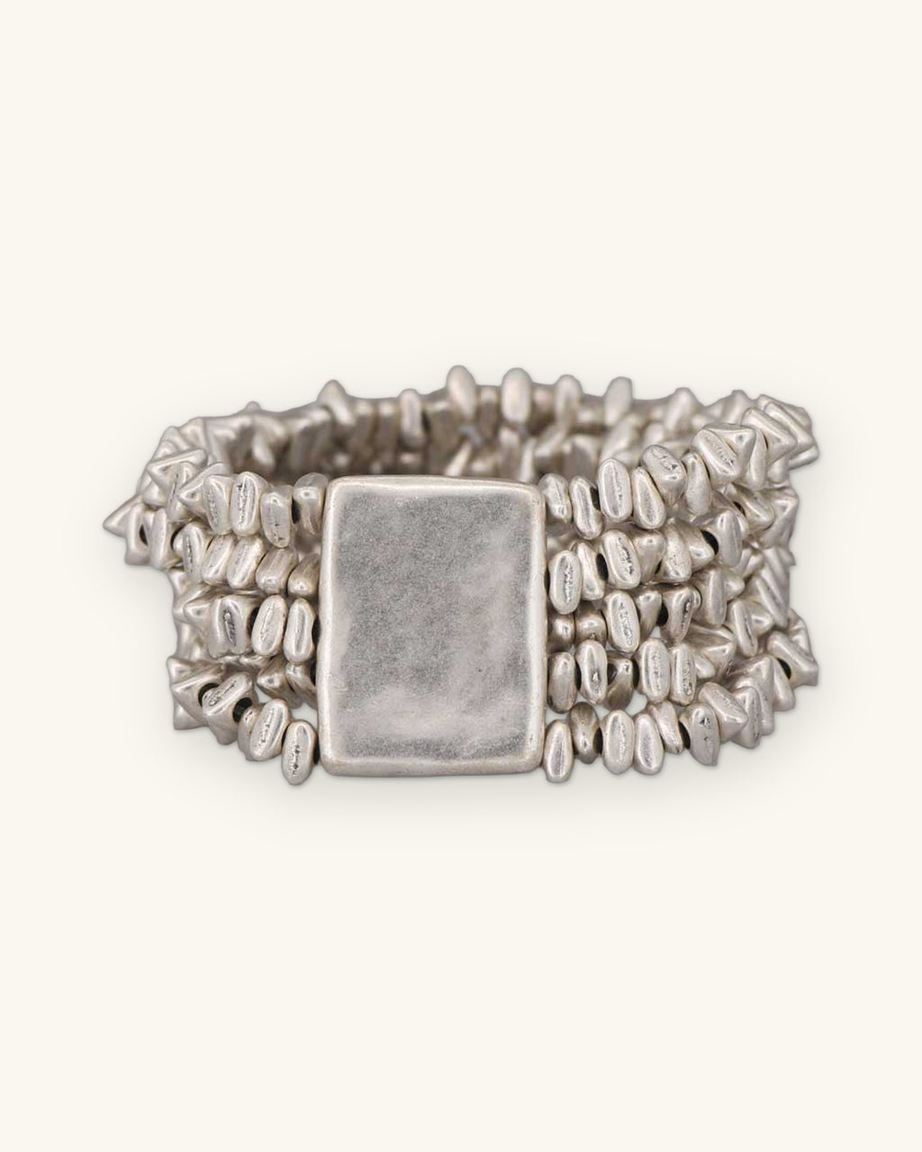 Multi-strand pewter pebble bead stretch bracelet with a rectangular plate, cast in Türkiye, shown on a sand background