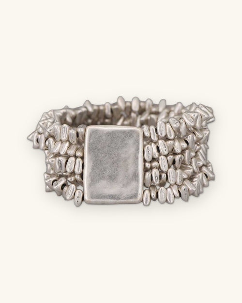 Multi-strand pewter pebble bead stretch bracelet with a rectangular plate, cast in Türkiye, shown on a sand background