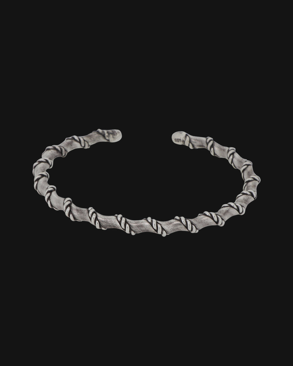 Oxidized sterling silver open cuff wrapped in a rope spiral, front view, shown on a black background