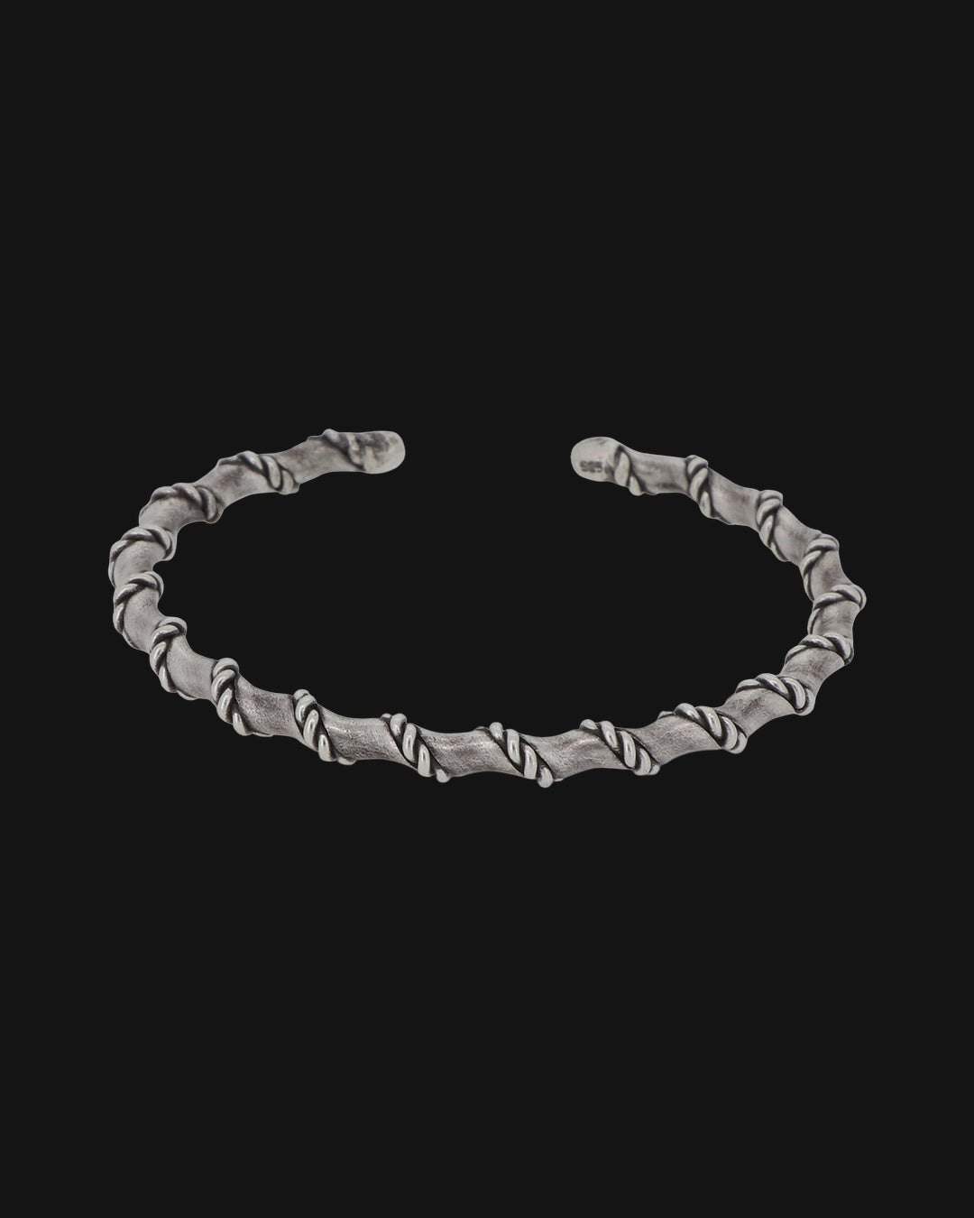 Oxidized sterling silver open cuff wrapped in a rope spiral, front view, shown on a black background
