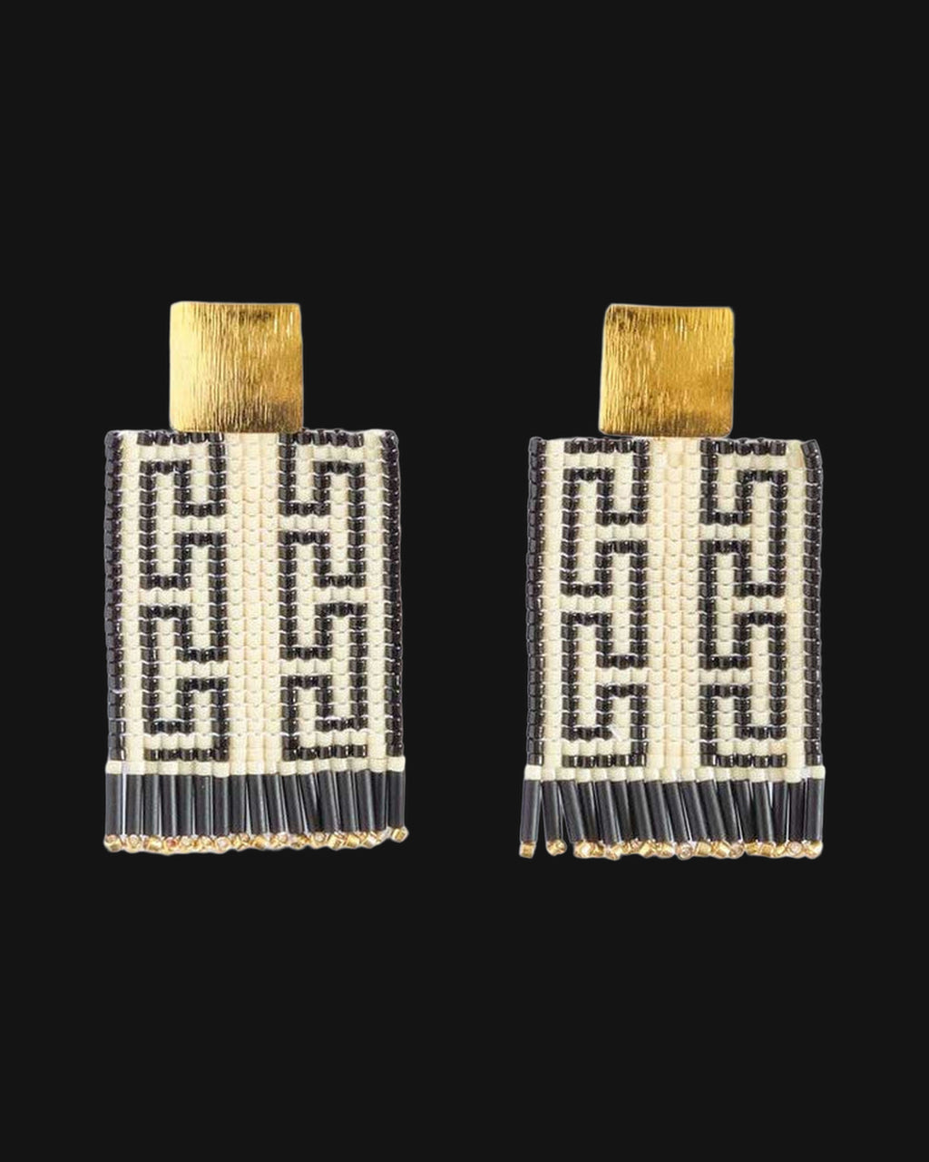 Pair of rectangular black and cream Greek key bead earrings with brass square tops, front view, shown on a black background