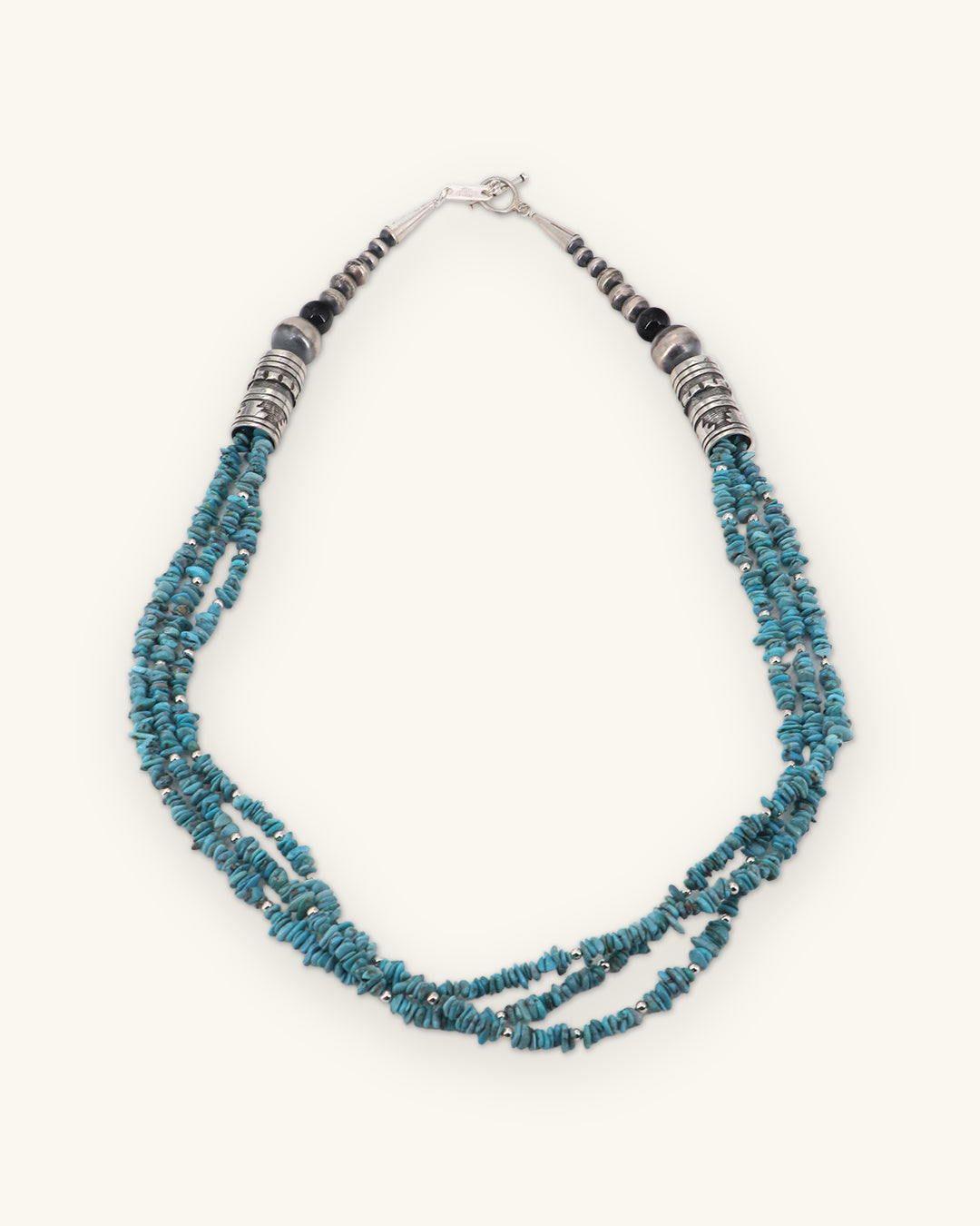 Triple-strand Kingman turquoise chip and sterling silver bead necklace, Southwest style made in the USA, shown on a sand background