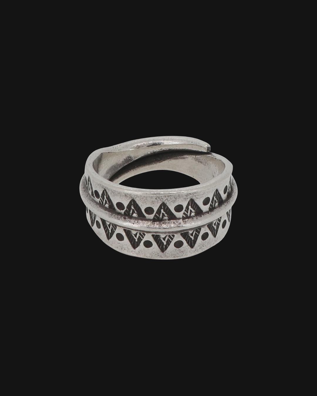 Wide silver wrap band ring stamped with triangles and dots on either side of a raised ridge, shown on a black background